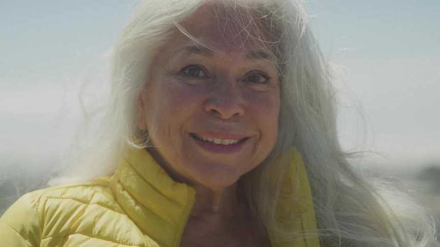 The woman is smiling on a windy day