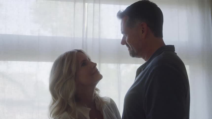 Happy couple slow dancing indoors in front of a window