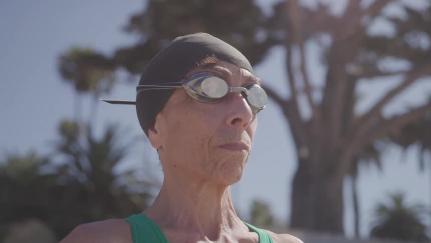 Close up portrait of an middle aged female swimmer standing outdoors during daytime