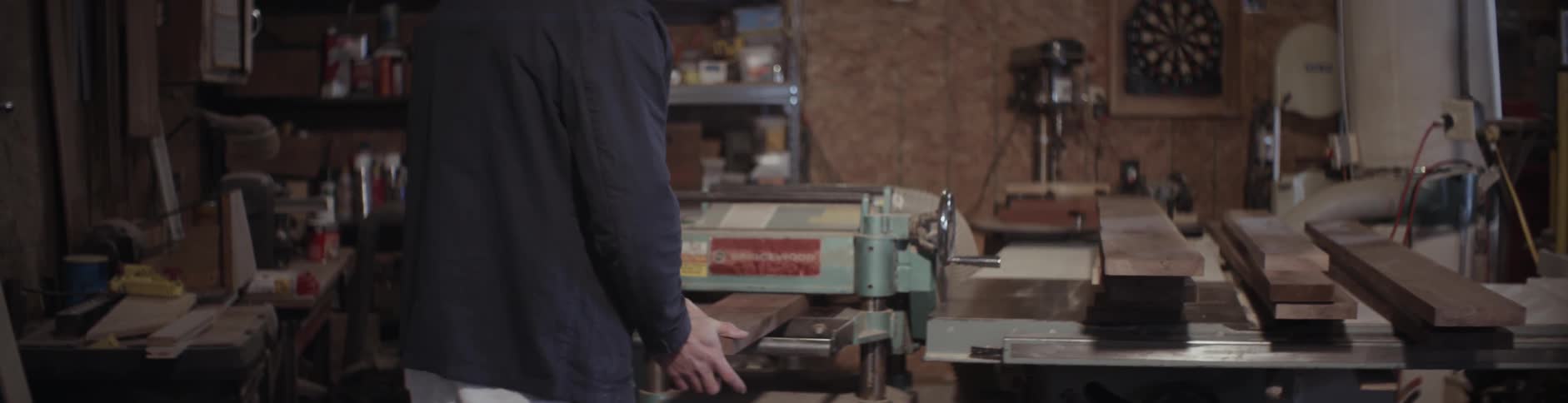 A man feeds a piece of lumber into a machine