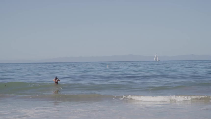 The person is standing in the water before going for a swim