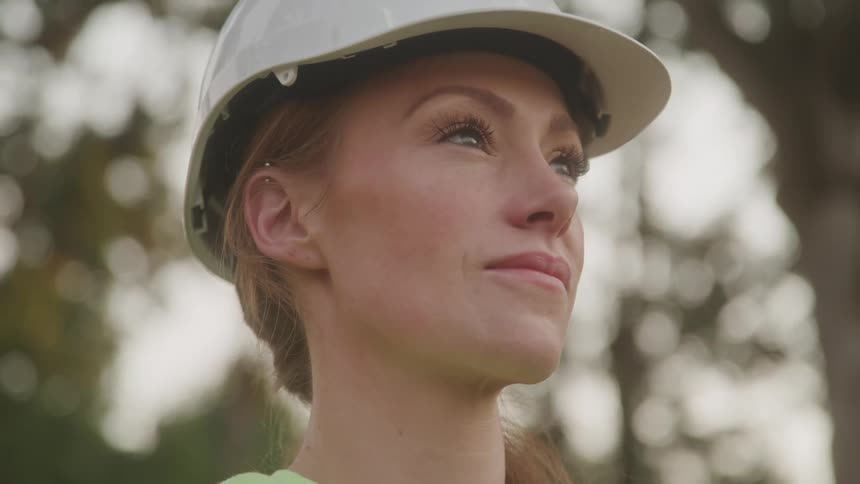 Portrait of a confident female construction worker looking up outdoors