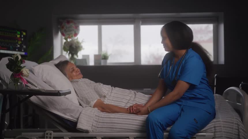 A nurse is consoling a patient in the hospital