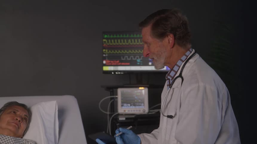 A doctor is talking with a patient and using a tablet