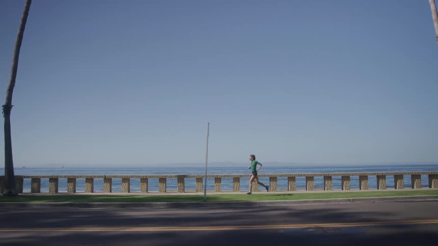 Woman running on the shore of a tropical beach during the day