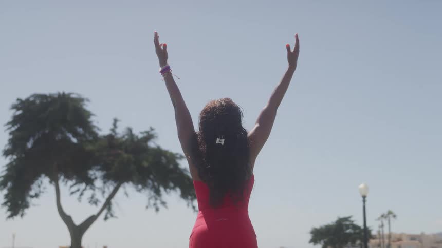 The woman raises her arms while doing yoga