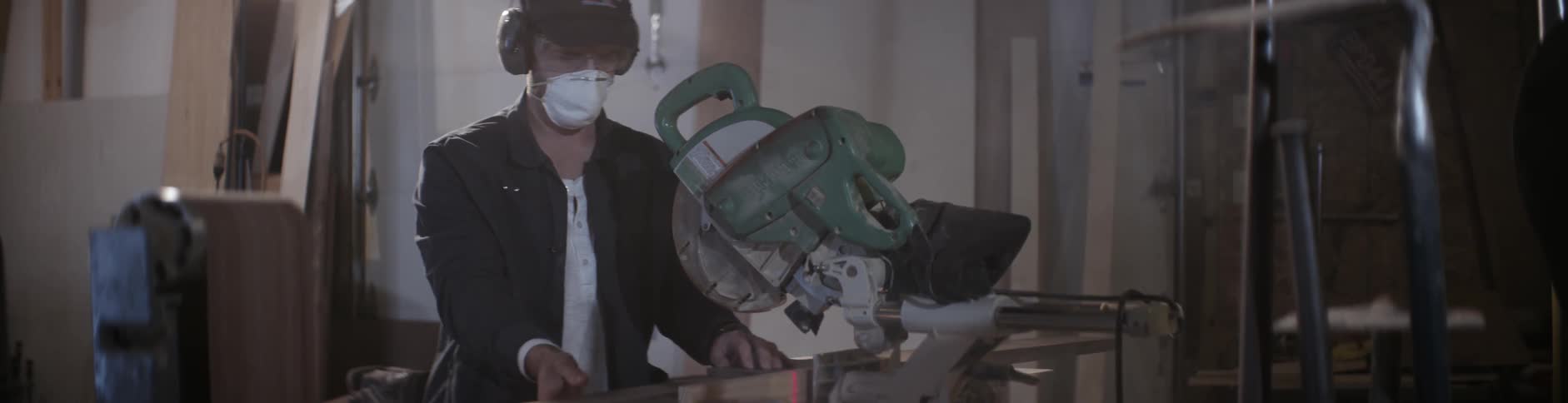 A man uses a table saw to cut lumber