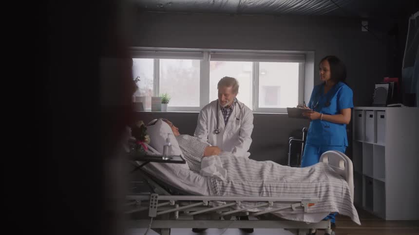 The doctor examines a patient as a nurse watches