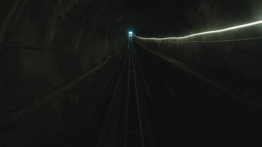 Inside a moving subway tunnel with only one light