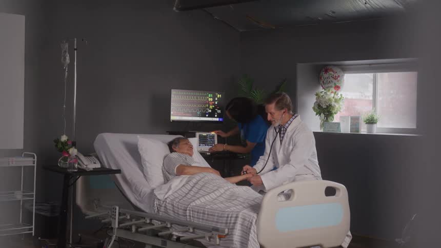 The doctor is examining the patient in the hospital room