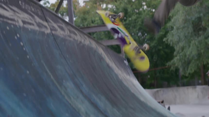 The video shows a young man skateboarding on a concrete ramp he is wearing a black shirt and tan pants and is performing a trick on the board