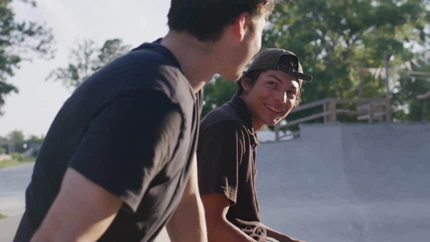 Two friends talk in the skate park