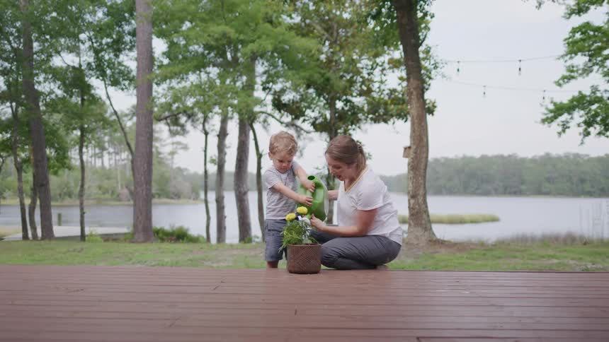 Mother and son watering flowers in a vase