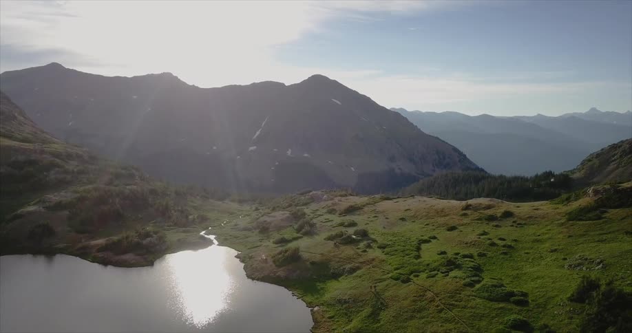 A lake near the top of a green mountain