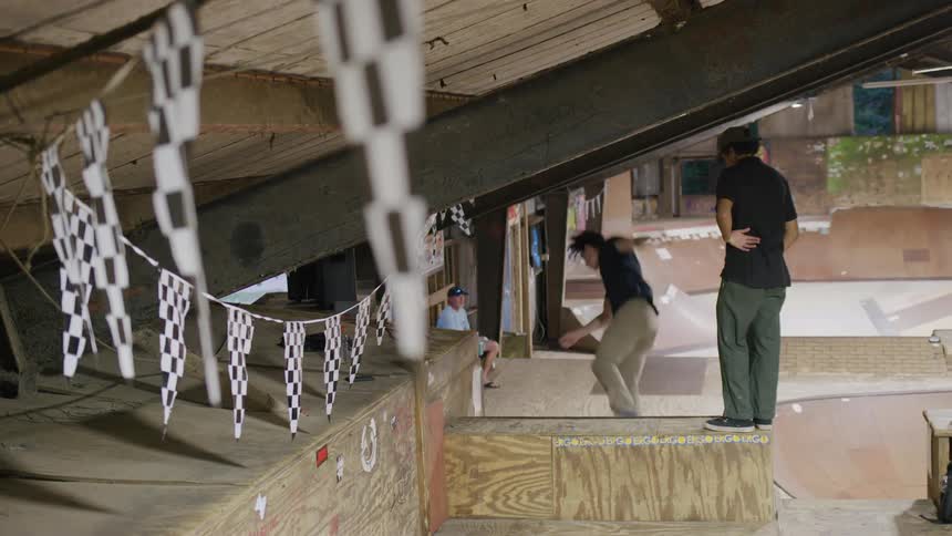 The teenager does a flip on the skate ramp