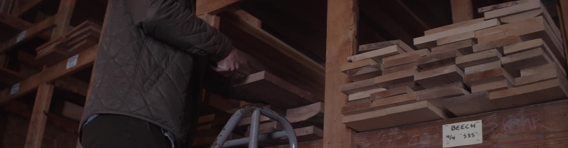 A man uses measuring tape on boards