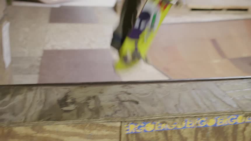 People are skateboarding in an indoor skatepark while a young man cheers on a skateboarder