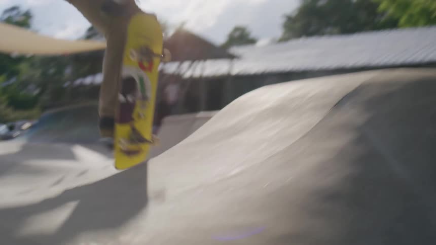 A young male skateboards in an outdoor rink during daytime