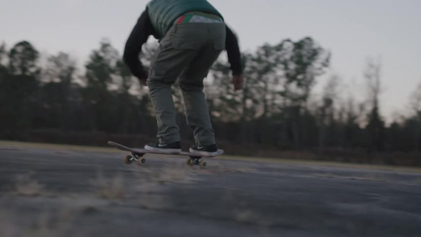 The man does a kick flip on his skateboard