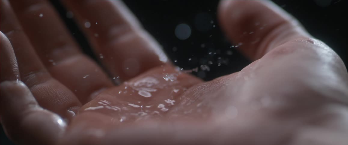Water dropping on the palm of a hand