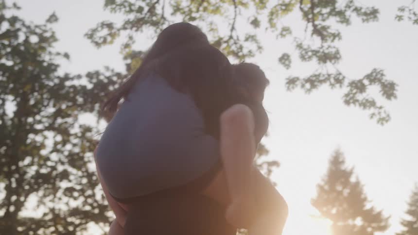A woman is piggybacking on a man and spinning