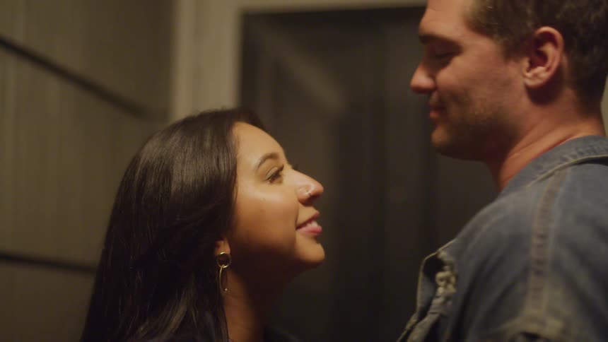 Man kisses a womans forehead as they embrace affectionately