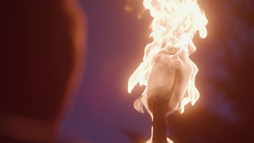 Lit torch with intense flames lights up the surrounding darkness