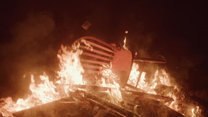 A wooden chair burns in a wood fire