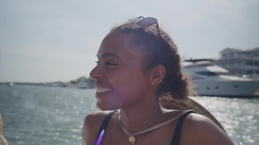 Smiling woman with sunglasses resting on her head during a boat ride