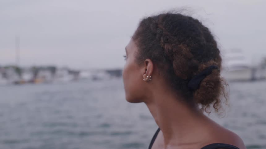A woman near a beach with many boats nearby
