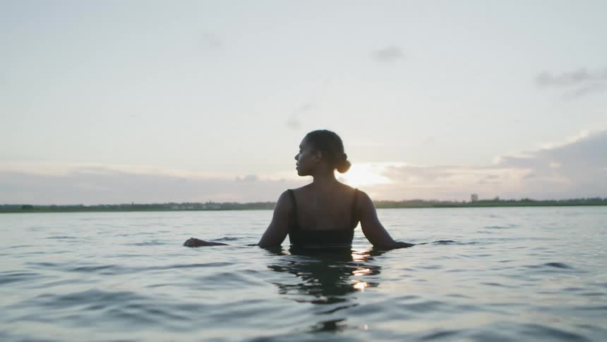 A woman standing calmly in the water enjoying nature