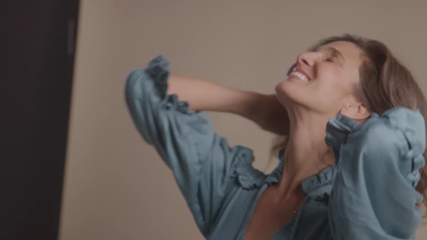 Woman smiles softly while looking up during a photo shoot