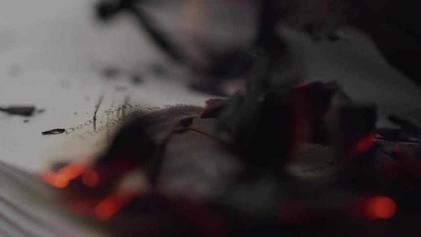 Smoke rises from a burning pile of papers