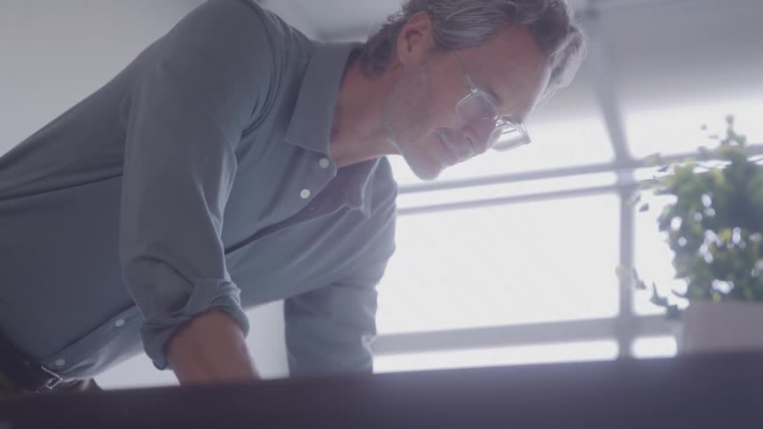 Man with glasses in an office working on a project