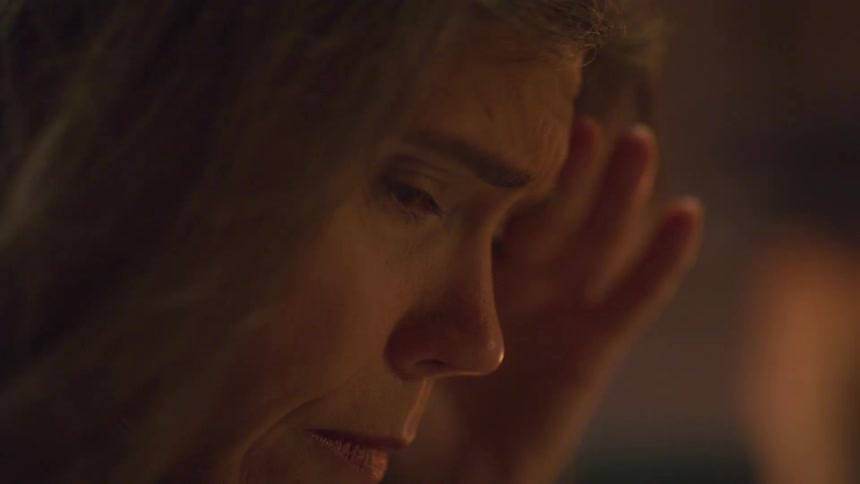 A closeup side profile of a middleaged woman is shown she is looking down with a hand resting on the side of her head appearing stressed or deep in thought