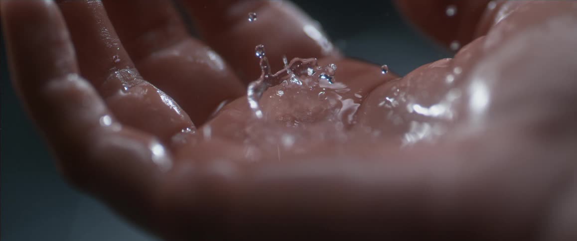Water dropping on the palm of a hand