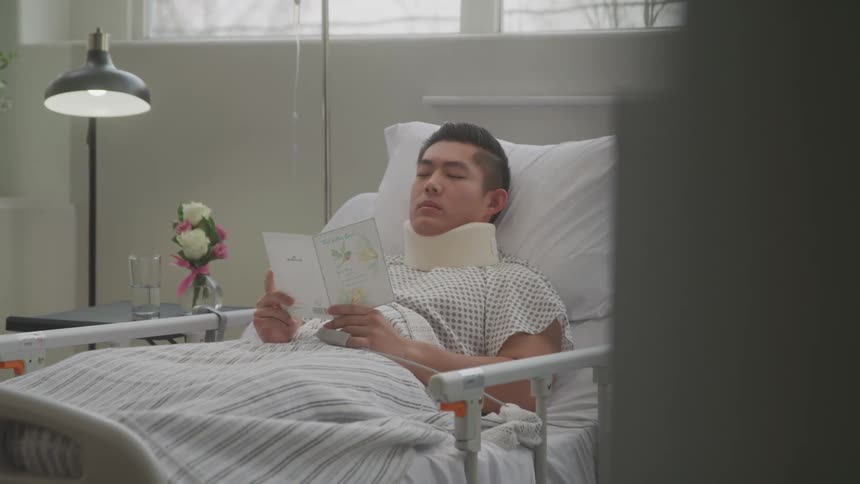 Patient lying in hospital bed reading a letter