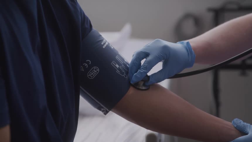 A healthcare worker checks a patients blood pressure