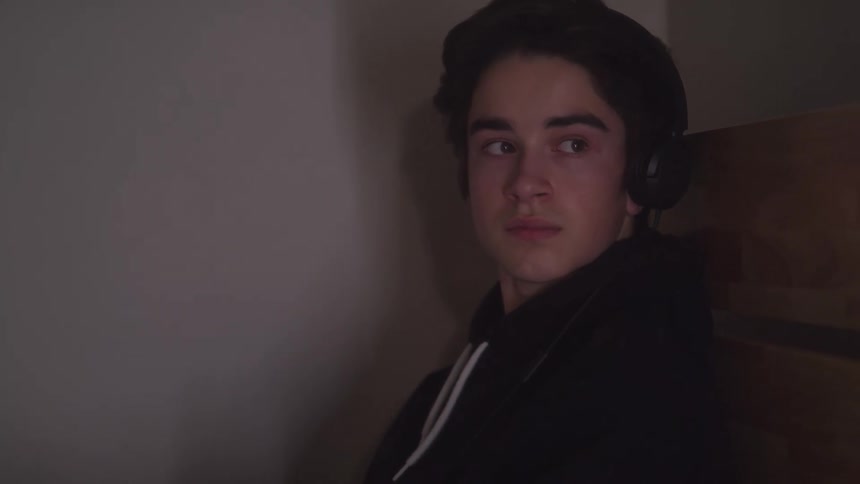 Boy with headphones looking to the side while standing indoors
