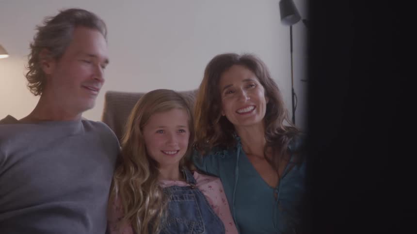 Happy family smiles together on a couch