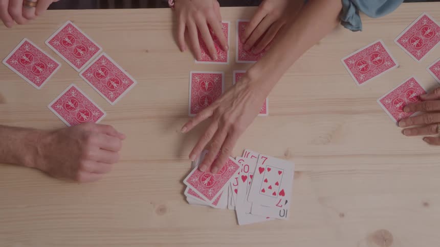 Three people at a table playing cards