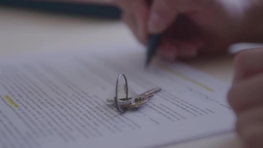Person signing document finalizing sale of a property
