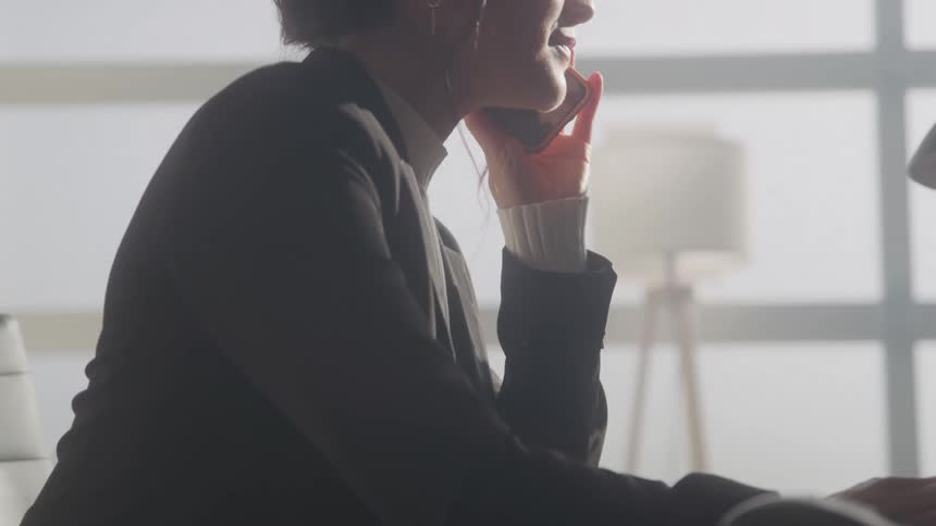 A woman is communicating with someone on mobile and she is laughing