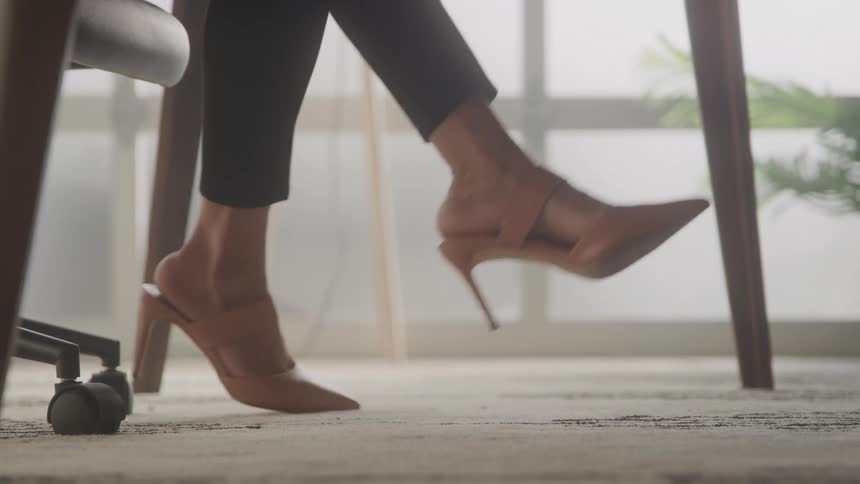 Moving legs of a seated woman in high heels