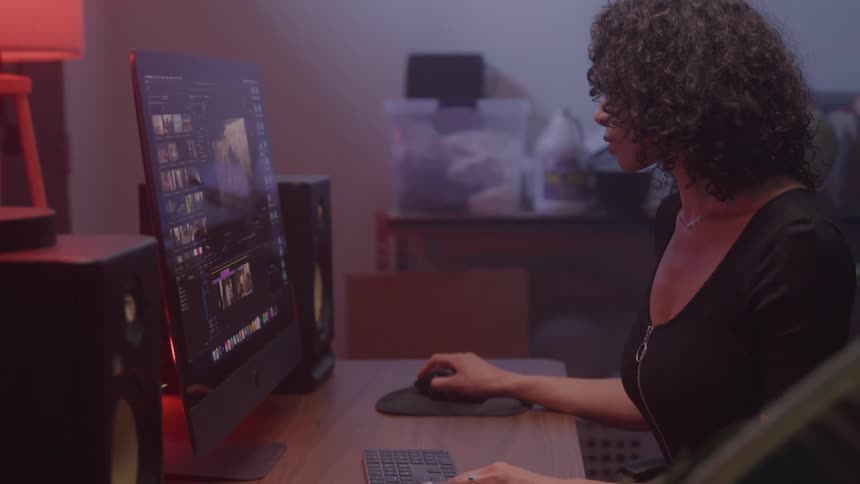 Woman works on video editing at a desktop computer
