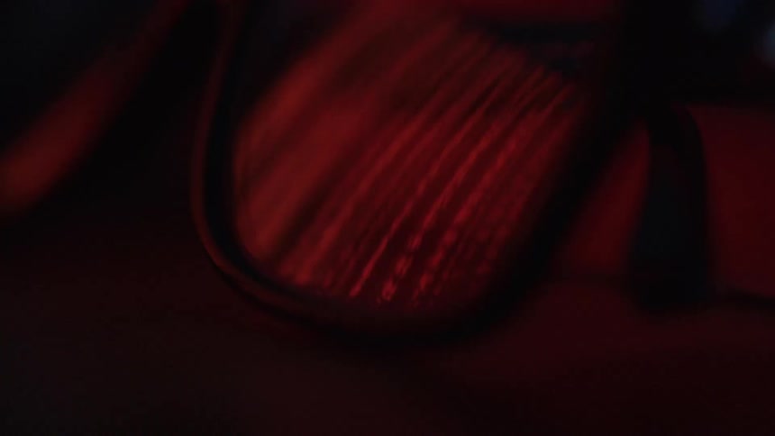 Red light reflects off eyeglass lenses