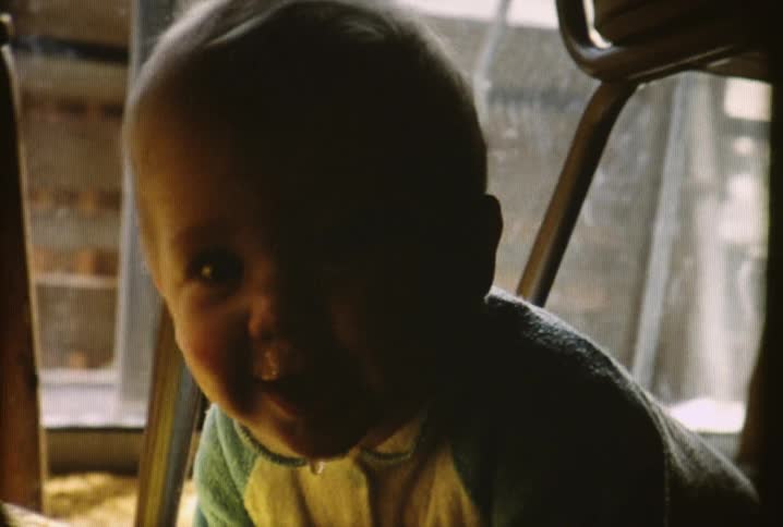 A baby is laughing and crawling around