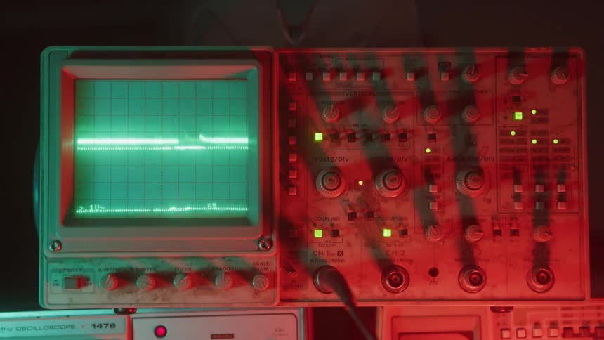 Closeup of an oscilloscope glowing under red light