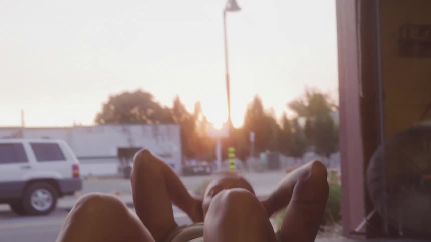 Woman does situps with hands on her head during sunrise