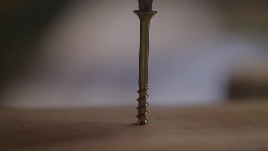 Close up drilling a screw into wood